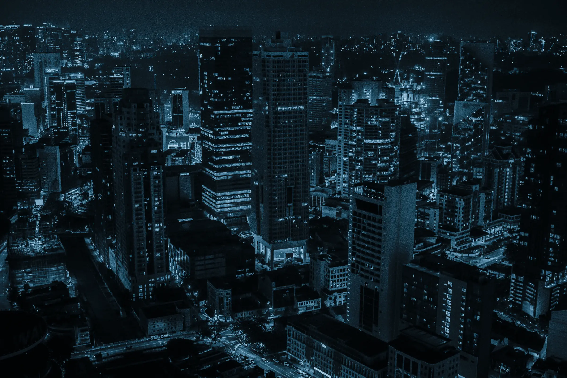 A dense city at night, lit by its infrastructure